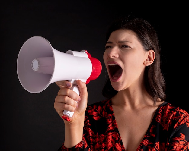 Linda mulher com um megafone gritando, espaço preto