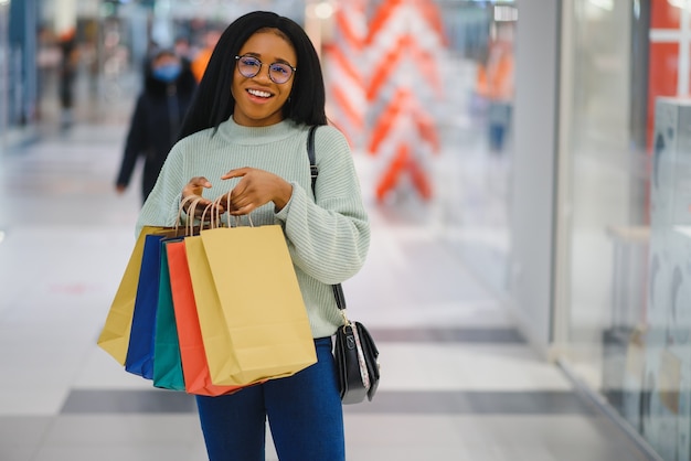 Linda mulher comprando sorrindo e segurando sacolas