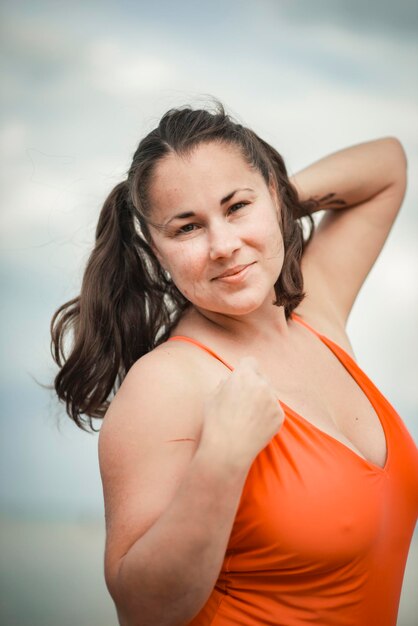 Linda mulher de 40 anos na praia em maiô plus size
