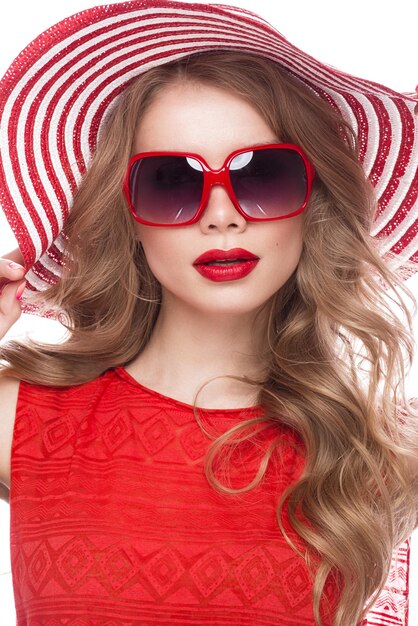 Linda mulher de chapéu com maquiagem colorida lábios vermelhos cachos e manicure rosa