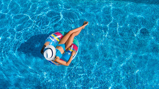 Linda mulher de chapéu na piscina aérea vista superior de cima