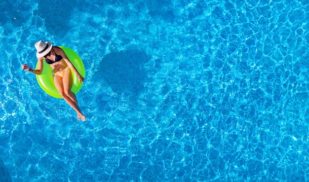 Foto linda mulher de chapéu na piscina vista aérea de cima jovem relaxa e se diverte