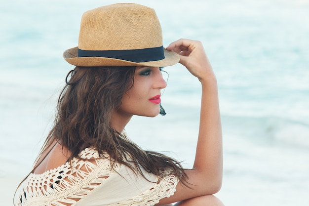 Foto linda mulher de chapéu na praia