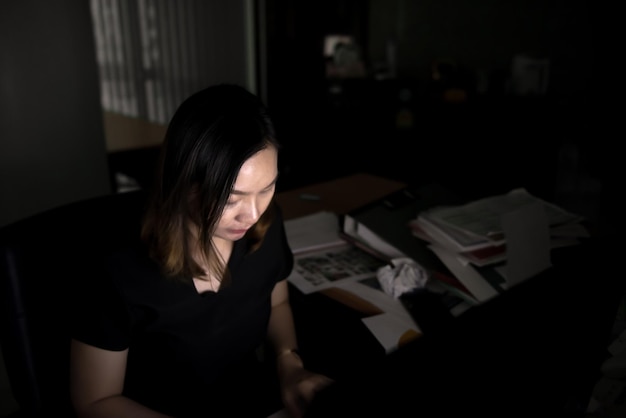 Linda mulher de escritório asiático trabalhando horas extras à noitePessoas da TailândiaConceito de pessoas estressadasTrabalhar até tarde