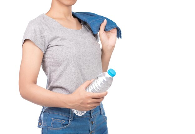 linda mulher de jeans segurando a garrafa de água isolada no fundo branco.