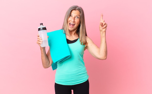 Linda mulher de meia-idade se sentindo um gênio feliz e animado depois de realizar uma ideia. conceito de fitness