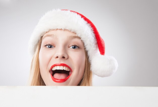 Linda mulher de Natal com chapéu de Papai Noel segurando o tabuleiro vazio, isolado no fundo branco