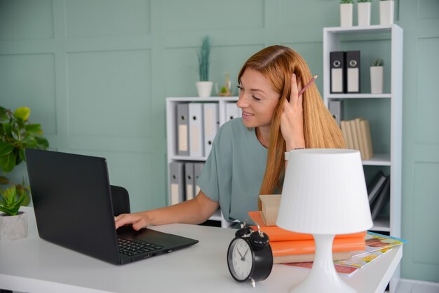 Linda mulher de negócios trabalha no escritório como freelancer de laptop no trabalho