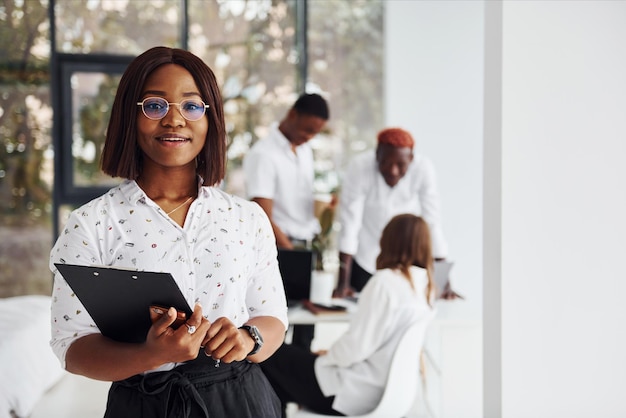 Linda mulher de óculos na frente de seus colegas Grupo de empresários afro-americanos trabalhando juntos no escritório