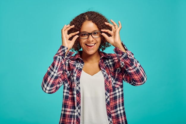 Foto linda mulher de óculos, parede azul, emoção positiva. expressão facial, pessoa do sexo feminino olhando para a câmera no estúdio, conceito emocional, sentimentos