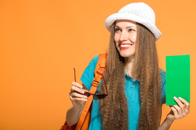 linda mulher de verão usando óculos escuros de chapéu sobre fundo laranja