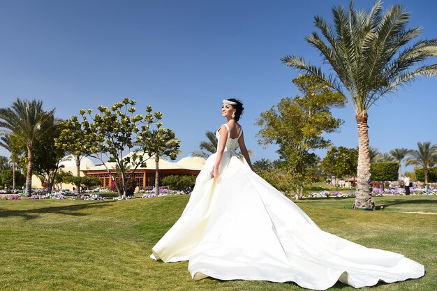 Linda mulher de vestido de noiva cor branca menina tem maquiagem elegante e cabelo em pé verão ensolarado ao ar livre no fundo natural noiva na celebração do feriado