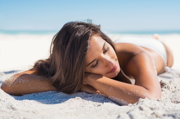 Linda mulher deitada na areia