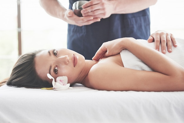 Linda mulher deitada na mesa de massagem no spa.