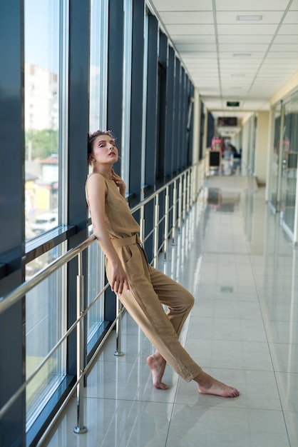 Linda mulher descalça em pé dentro do prédio e olhando para a frente