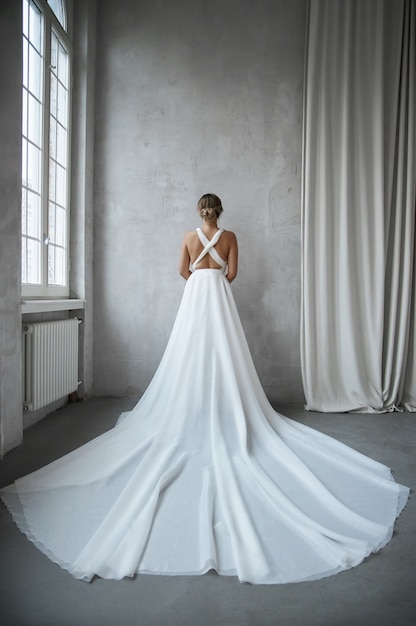 Linda mulher esbelta em um vestido de noiva branco, nova coleção de vestidos para a noiva. Ruído, fora de foco