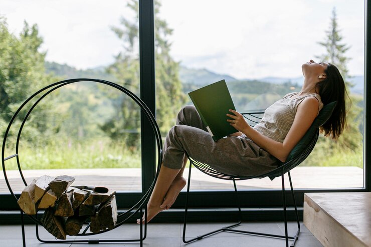 Foto linda mulher estilosa relaxando com um livro em um chalé moderno com vista para as montanhas tempo de lazer