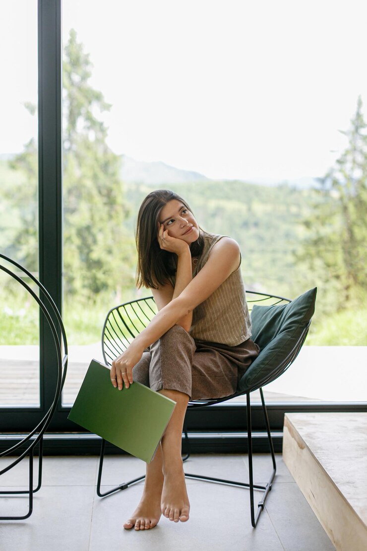 Foto linda mulher estilosa relaxando com um livro em um chalé moderno com vista para as montanhas tempo de lazer