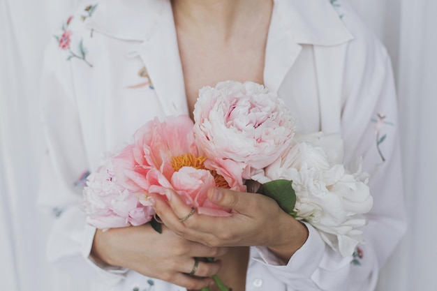 Linda mulher estilosa segurando buquê de peônia Sensual jovem boho feminino com flores nas mãos