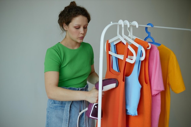 Linda mulher experimentando roupas, guarda-roupa, estilo jovem, fundos isolados inalterados