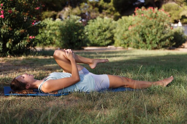 Linda mulher fazendo ioga no parque matinal Estilo de vida saudável Concepção ao ar livre Esporte Mulher retrato da natureza fazendo exercícios Estilo de vida saudável