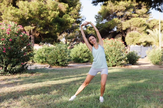 Linda mulher fazendo ioga no parque matinal Estilo de vida saudável Concepção ao ar livre Esporte Mulher retrato da natureza fazendo exercícios Estilo de vida saudável