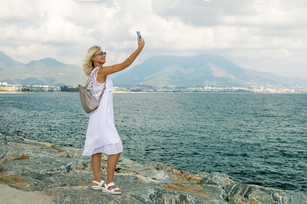 Linda mulher feliz aproveitando as férias de verão em Alanya Turquia Turista sorridente fazendo foto ou selfie com telefone celular