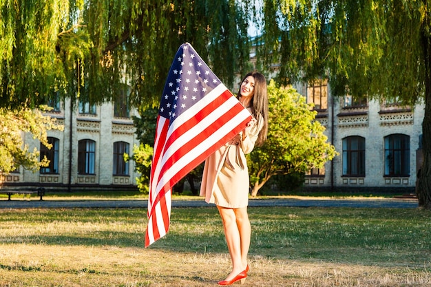 Linda mulher feliz com a bandeira americana comemorando o dia da independência