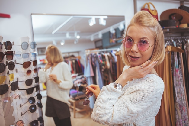 Linda mulher feliz desfrutando de compras na loja de roupas