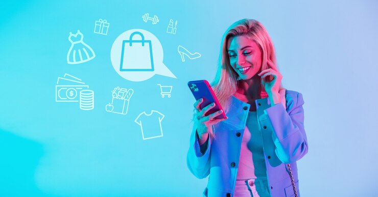 Foto linda mulher feliz e sorridente em roupas da moda, segurando o smartphone e compras online com ícones de compras sobre fundo azul. menina faz compras na internet pelo aplicativo