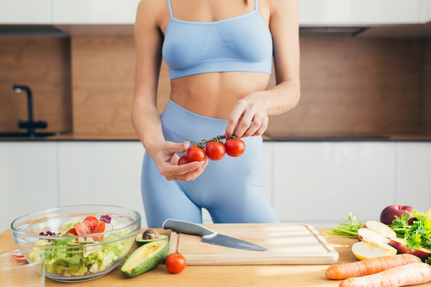 Linda mulher fitness, prepara comida saudável em casa,