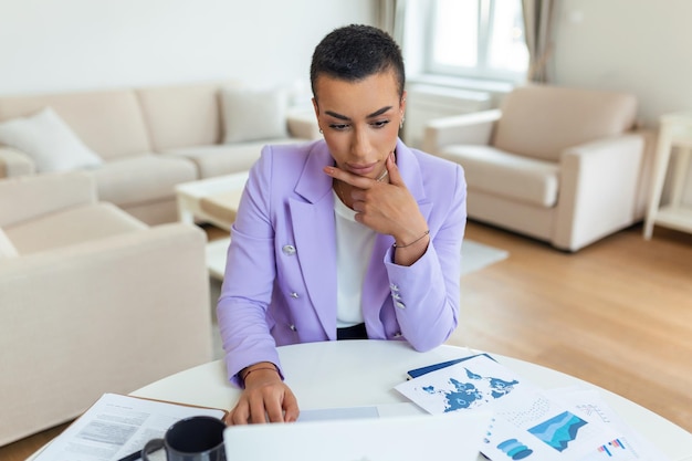 Linda mulher freelancer observando informações para planejar o projeto fazendo trabalho remoto via laptop mulher rindo enquanto lê e-mail no dispositivo laptop moderno