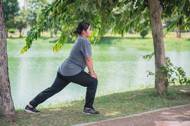 Linda mulher gorda asiática joga ioga no parqueprecisa de corpo magro