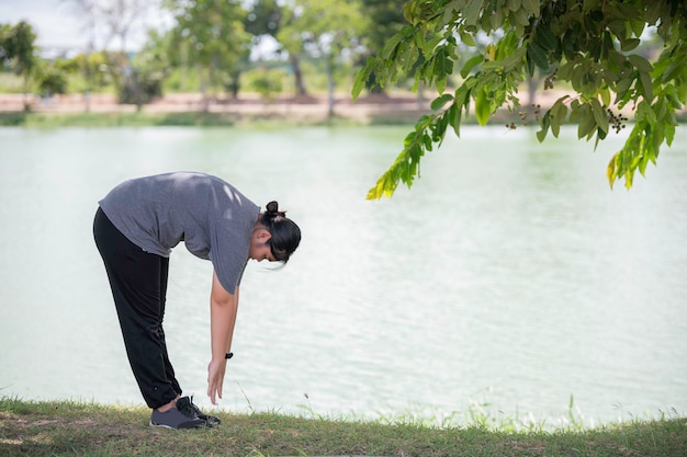 Linda mulher gorda asiática joga ioga no parquePrecisa de corpo magro