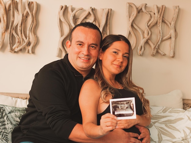 Linda mulher grávida com o marido com um eco na mão do bebê
