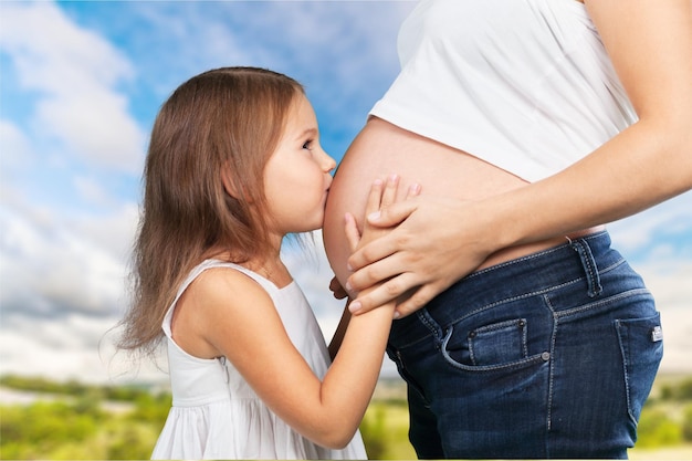 Linda mulher grávida com sua filha. Isolado no fundo