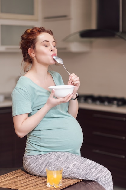 Linda mulher grávida comendo cereais