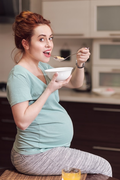 Linda mulher grávida comendo cereais