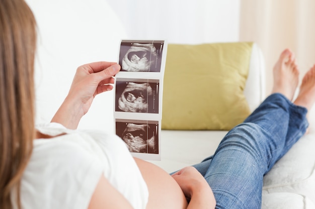 Linda mulher grávida olhando para uma sonografia