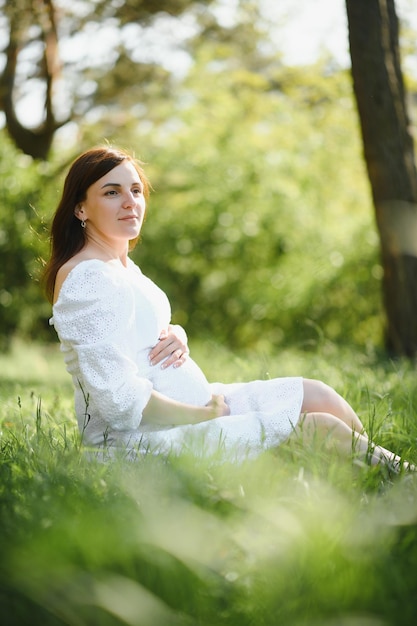 Linda mulher grávida relaxante fora no parque