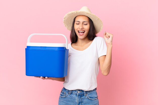 Linda mulher hispânica com um freezer portátil