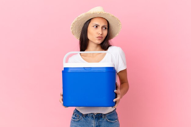 Linda mulher hispânica com um freezer portátil