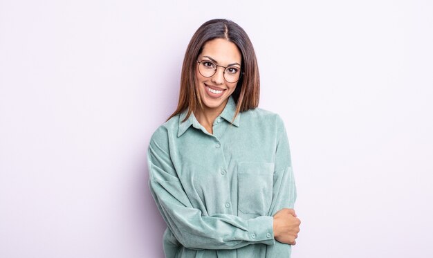 Linda mulher hispânica rindo tímida e alegre, com uma atitude amigável e positiva, mas insegura