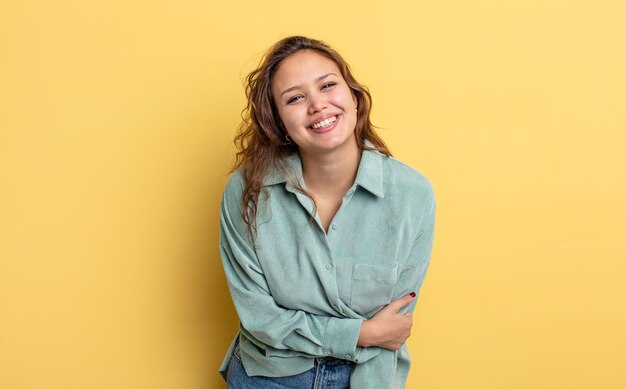 Linda mulher hispânica rindo tímida e alegre, com uma atitude amigável e positiva, mas insegura