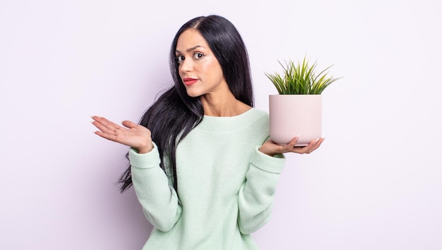 Linda mulher hispânica se sentindo perplexa, confusa e em dúvida. conceito de planta de casa