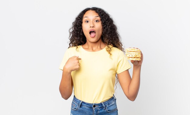 linda mulher hispânica segurando um bolo de dieta de arroz