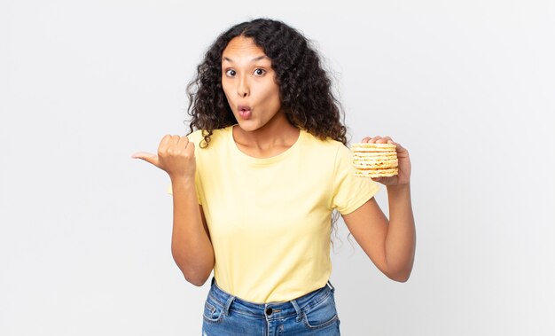 Linda mulher hispânica segurando um bolo de dieta de arroz