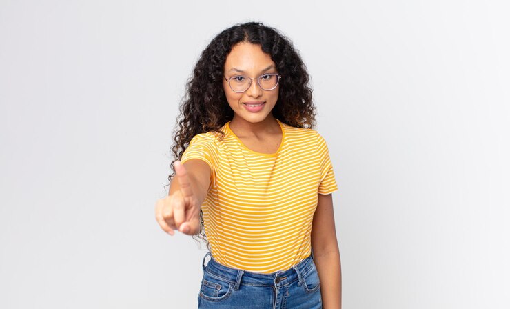 Foto linda mulher hispânica sorrindo com orgulho e confiança fazendo a pose número um triunfantemente, sentindo-se uma líder