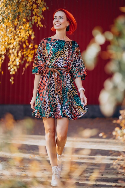 Linda mulher idosa em um vestido colorido do lado de fora da rua de outono