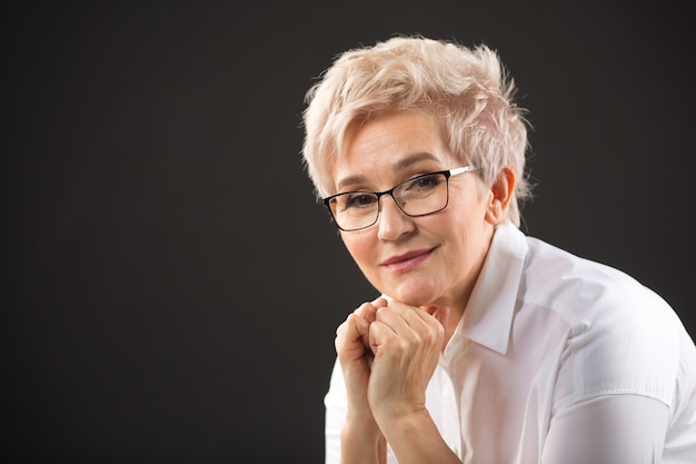 Linda mulher idosa em uma camisa branca e óculos